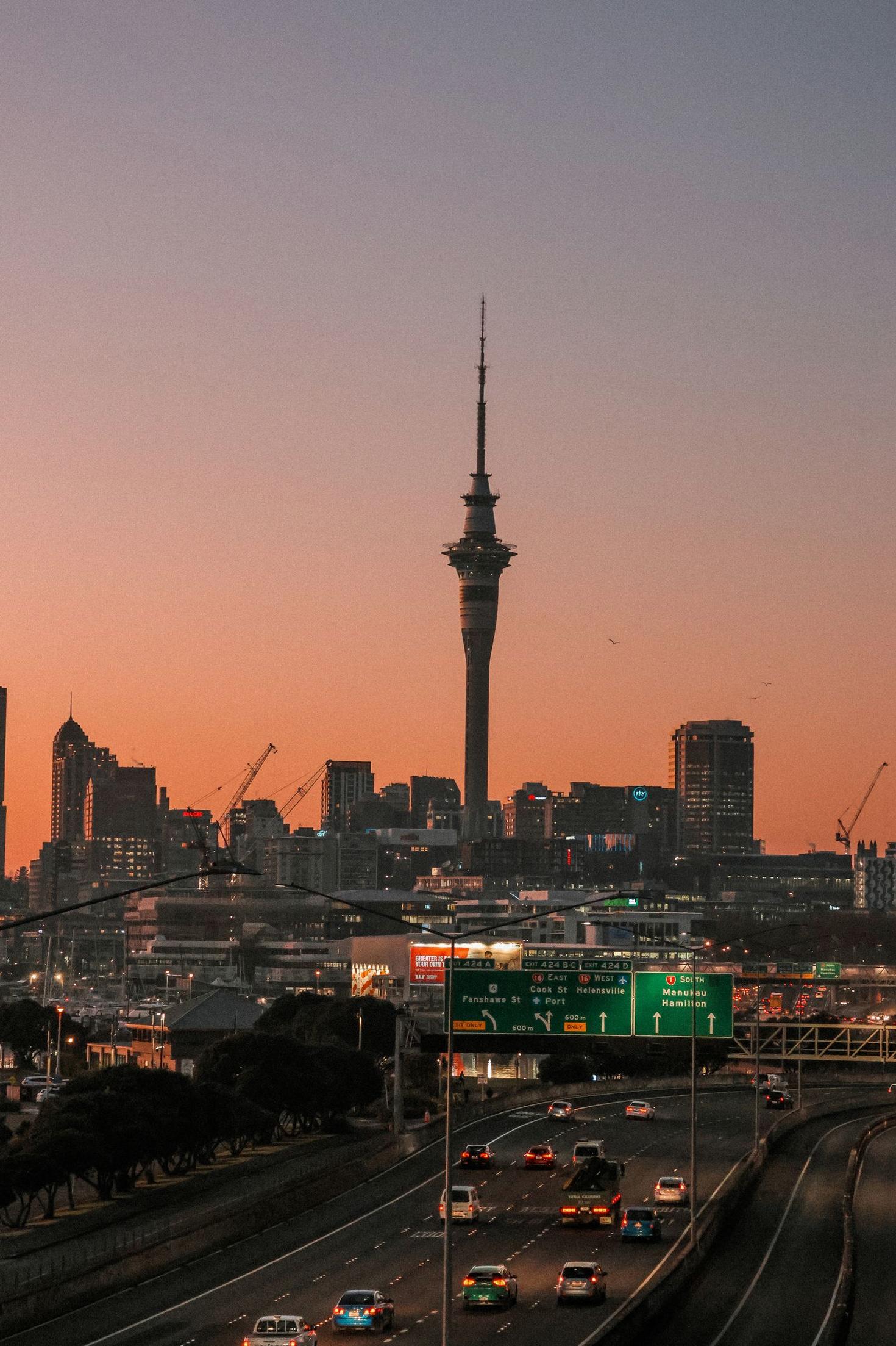 Auckland skyline with city lights and Sky Tower at sunrise